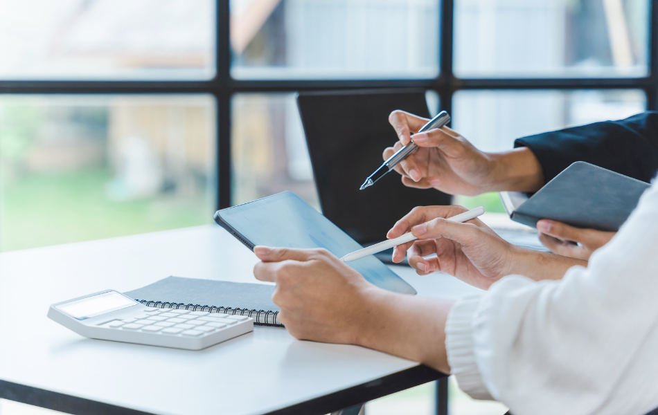 Hands holding and pointing at a tablet in a work environment